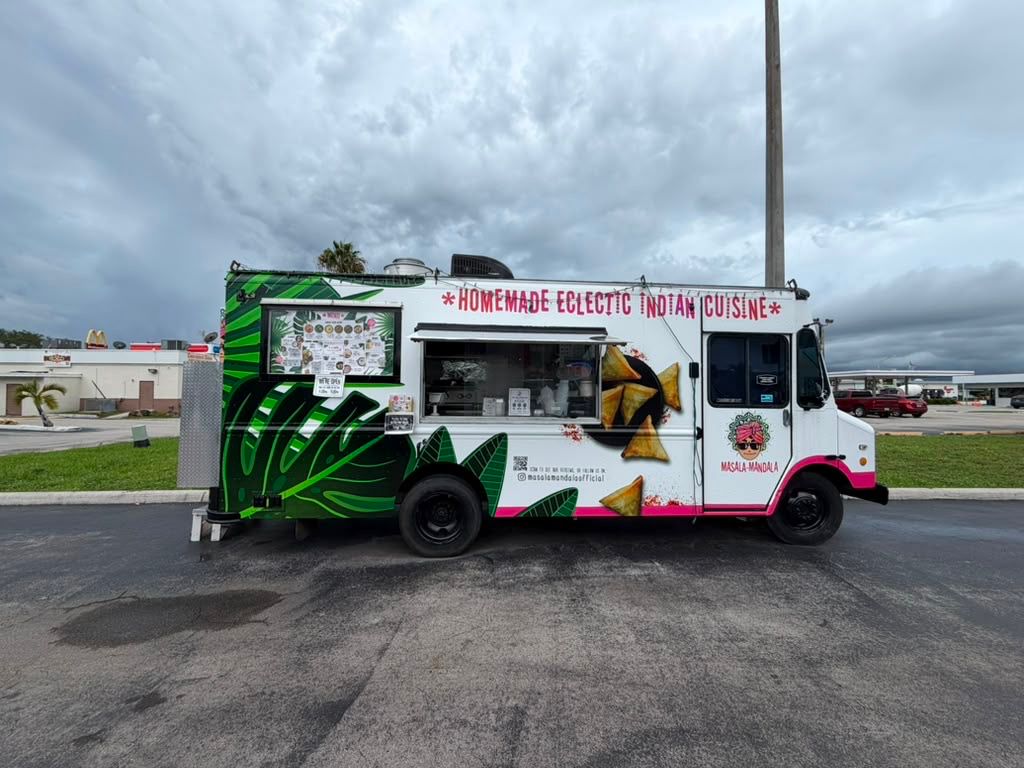 The Masala Mandala food truck, painted with green tropical leaves and samosas beneath the words “Homemade Eclectic Indian Cuisine”